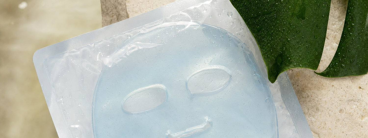 Máscara facial de hidrogel azul em embalagem selada sobre pedra clara