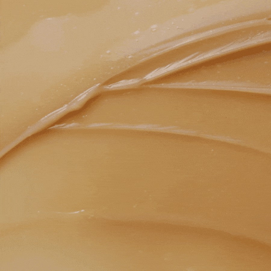 Macro da textura do creme espalhada, tom bege.