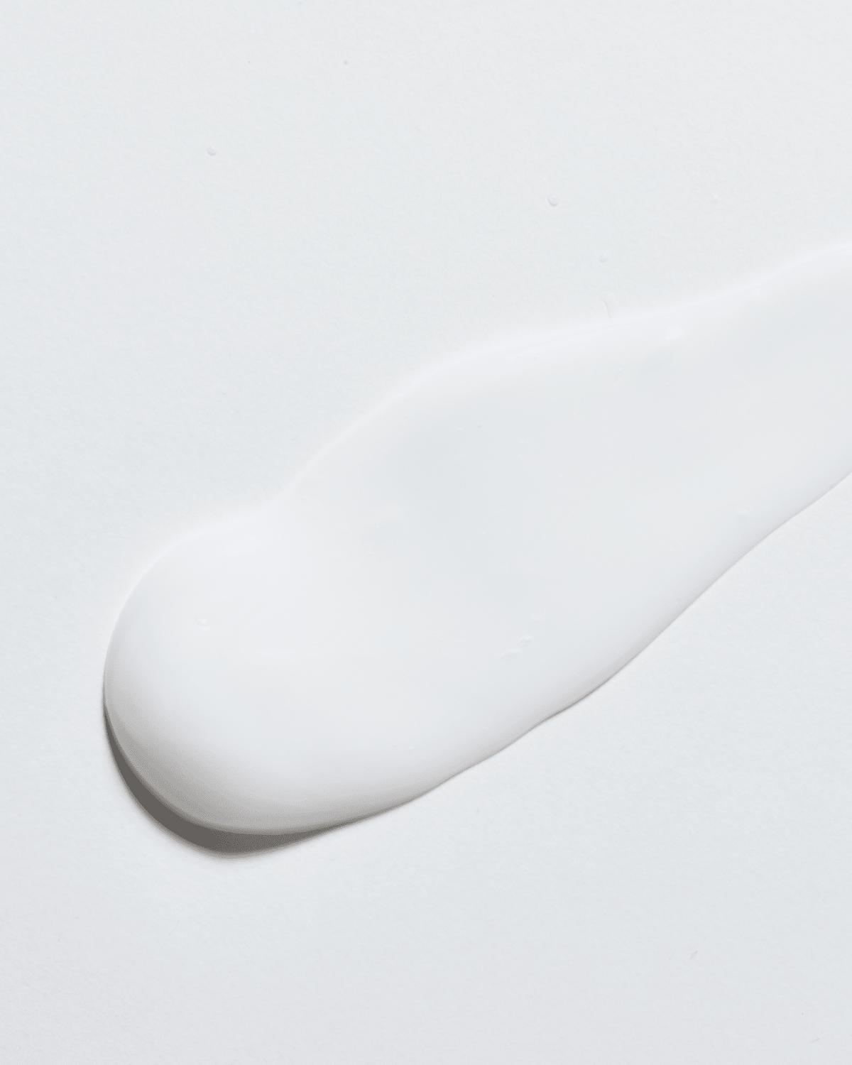 Porcao do creme espalhada sobre superficie branca, mostrando a textura