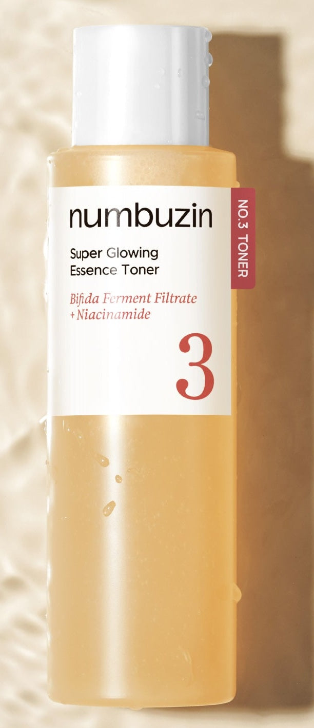 Frasco do tonico-essencia da linha No.3 da numbuzin deitado sobre superficie com agua, rotulo branco legivel.